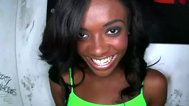 Black chick is teasing a large dick in a glory hole and she smiles
